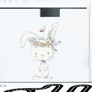 Close-up of a cute rabbit wall sticker with a floral wreath on a white drawer panel