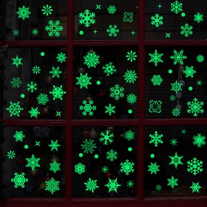 Luminous snowflake window stickers in glowing green for Christmas holiday glass decor