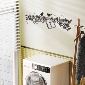Black silhouette wall sticker of birds on a laundry line above a white washing machine