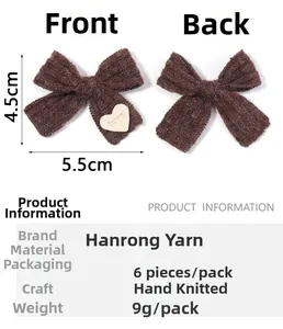 Detail von zwei braunen Strickschleifen-Clips mit Herz-Aufnähern und handgefertigter Struktur