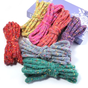 Macro shot of colorful speckled knit yarn bundles in red, yellow, purple, and blue hues