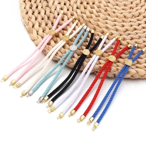 Détail de bracelets en cordon milanais tressé avec curseurs dorés gravés de feuilles
