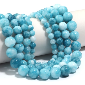 Macro detail of polished blue sea chalcedony beads showing natural white marble textures