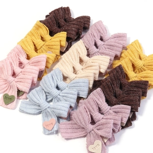 Detail von bunten Strickschleifen-Haarspangen mit Herz-Patches und Liebesgravur-Textur