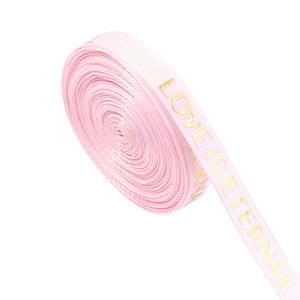 Close-up of pink rib ribbon with gold foil Love Is Eternal lettering for gift wrapping