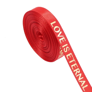 Detail of red grosgrain ribbon with gold foil stamped Love Is Eternal text for flower packing