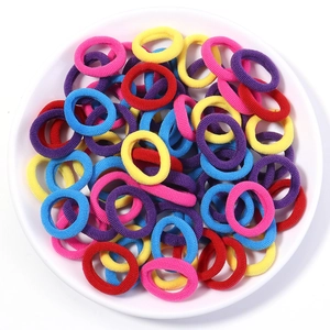 Macro detail of colorful high-elasticity hair ties stacked in a white display tray