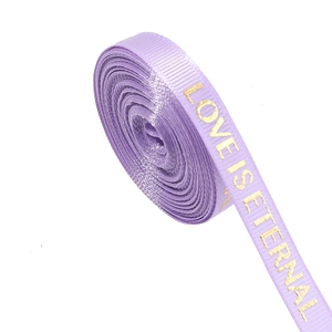 Close-up of purple ribbed ribbon with gold LOVE IS ETERNAL text for gift wrapping