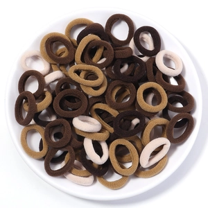 Close-up of elastic seamless hair ties in earth tones with ribbed texture on white plate