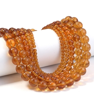Gros plan de perles en verre ambré transparent de différentes tailles pour bijoux DIY