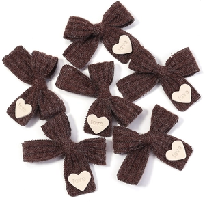 Detailansicht kaffeebrauner Strickschleifen mit Herz-Leder-Patches für DIY-Handwerk