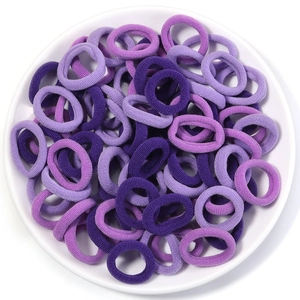 Detailed view of high-elastic purple fabric hair ties in a white ceramic dish