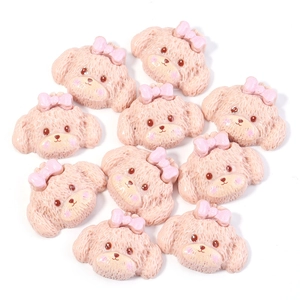 Detalle de dijes de resina de perrito rosa con lazo para pinzas de pelo y fundas de móvil DIY