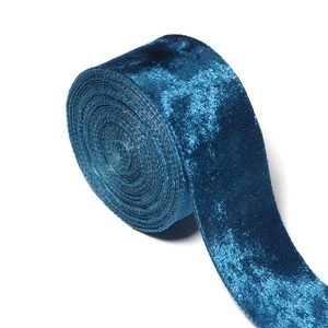 Close-up of peacock blue velvet ribbon showing luxury soft texture and metallic shimmer