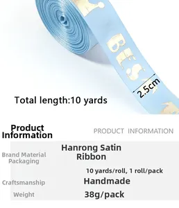 Detail of 2.5cm light blue satin ribbon with gold crown and BEST lettering for gifts
