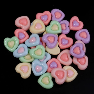Flat lay of colorful resin heart charms for DIY crafts in macaron candy colors