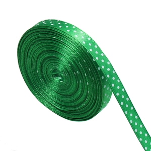 Close-up of emerald green satin ribbon with white polka dots for gift wrapping
