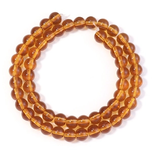 Vue macro de perles rondes en verre ambré avec grain interne pour bijoux DIY