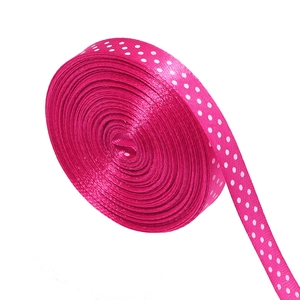 Detailed macro view of magenta polyester satin ribbon with classic white polka dots