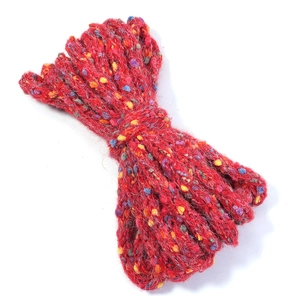 Close-up of red cable knit yarn with colorful speckles and soft fiber texture detail