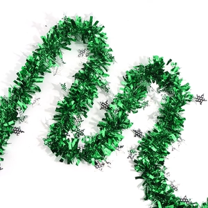 Detail of green Christmas tinsel garland with silver polka dot stars for party decor