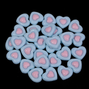 Macro view of blue and pink resin heart flatback charms for DIY crafts and accessories