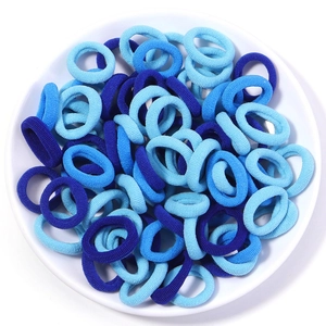 Close-up of high-elastic blue seamless hair ties in various shades on white plate