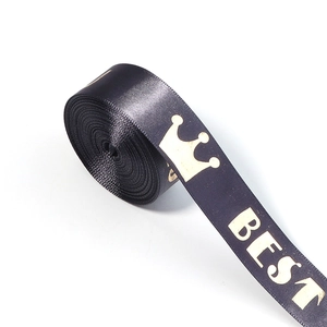 Close-up of black satin ribbon with gold crown and BEST text for luxury gift wrapping