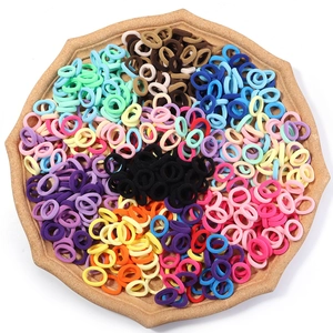 Elastic colorful hair ties set for girls in a wooden tray with vibrant assorted colors
