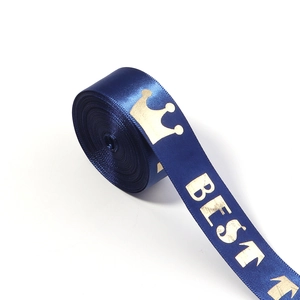 Macro detail of dark blue satin ribbon featuring gold foil crown and BEST lettering
