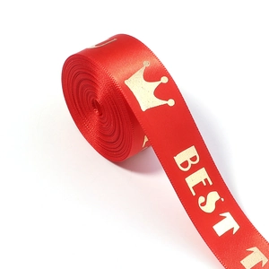 Close-up of red satin ribbon with gold crown and BEST print for gift packaging