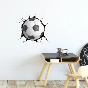 Detail of 3D broken wall football sticker showing realistic cracks and impact on white wall