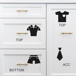Minimalist black clothing label stickers for wardrobe organization on white modern cabinets