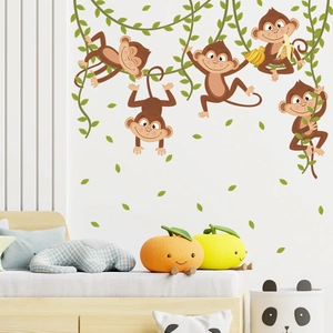 Detail view of cartoon monkeys and green vines wall stickers in a cozy nursery bedroom