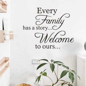 Family quote wall decal on white wall with wooden shelf and green plants for home decor