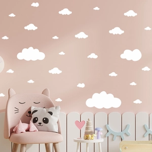 Detailed view of white cloud wall decals applied on a soft pink nursery wall background