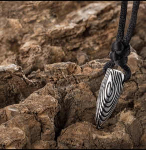 Vue macro d'un pendentif balle en acier titane avec texture d'empreinte digitale