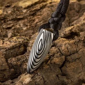 Pendentif balle en acier titane pour homme avec texture bois sur fond d'écorce naturelle