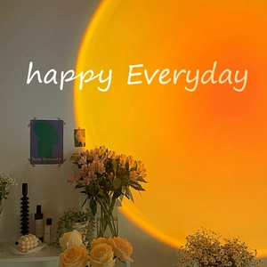 Sunset projection lamp casting warm orange light with happy everyday lettering on wall