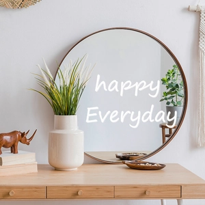 Modern round wall mirror with black frame and happy everyday quote on the glass