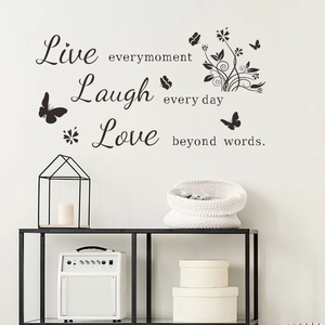 Detail showing Live Every Moment vinyl wall decal with butterflies in a modern home interior