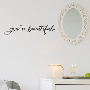Minimalist You Are Beautiful black vinyl wall sticker next to an elegant oval mirror