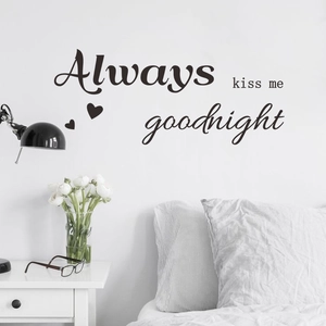 Close-up of Always kiss me goodnight black wall decal on a minimalist bedroom wall