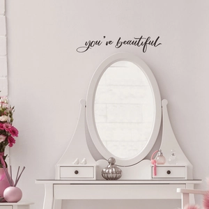 Detail of black 'you're beautiful' wall decal in an elegant bedroom setting
