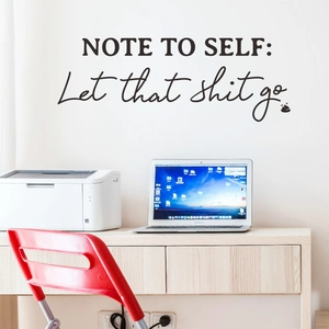 Sticker mural noir Note to Self sur un mur blanc minimaliste dans un espace de bureau