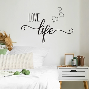 Detail of LOVE life wall sticker with heart accents in a modern bedroom setting