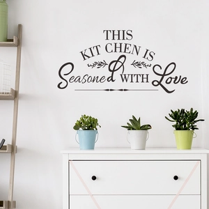 Black vinyl wall decal featuring This Kitchen is Seasoned with Love in artistic typography