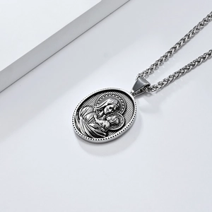 Détail macro du pendentif ovale argenté vintage à relief Vierge Marie et l'Enfant