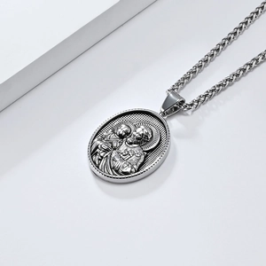 Détail du pendentif ovale en argent à relief avec chaîne épi sur support blanc