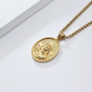 Vue détaillée du pendentif ovale doré avec gravure de Jésus sur une chaîne épi
